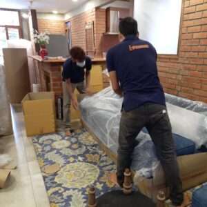 GoSmart Movers team packing a sofa for transportation